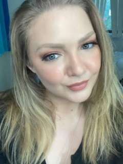 Ashleigh Thiel looks into the camera, tilting her head slightly with a soft smile.