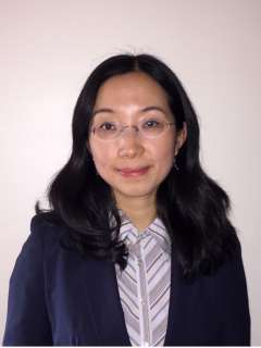 Anjie Zhen, PhD, headshot: woman with glasses in navy blazer
