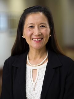 Dr. Linda M. Liau, a smiling woman with long dark hair, wearing a black blazer and white blouse. Her warm expression conveys professionalism.