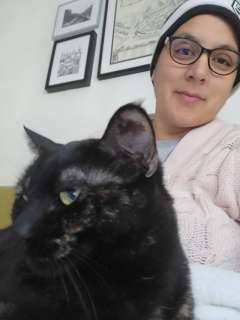 Mariam Usmani on couch with black cat in foreground