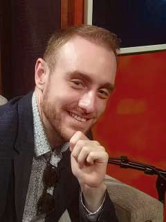 Dr. Alexander Strudwick Young, seated with microphone
