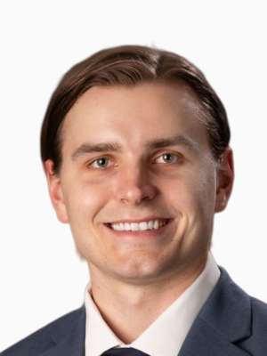Jackson Twyman smiling headshot in suit and tie