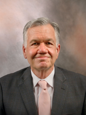 headshot of doctor greg Brent in grey suit