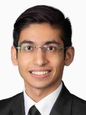 Headshot of person in suit and glasses smiling