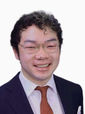 Raymond Yin smiling, wearing a suit and tie.