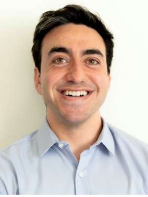 Smiling man in light blue shirt against white background