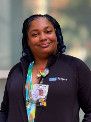 UCLA Health female employee smiling outdoors, wearing ID badge