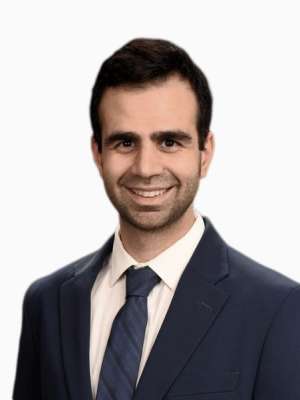 Headshot of a smiling man wearing a navy suit and tie