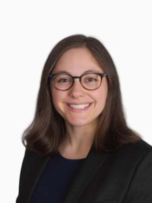 Headshot of smiling woman wearing glasses and a dark blazer