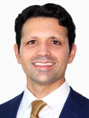 Headshot of a smiling man wearing a suit and tie