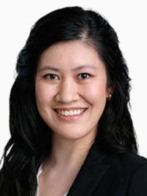 Smiling professional headshot of a woman with dark hair in a black blazer