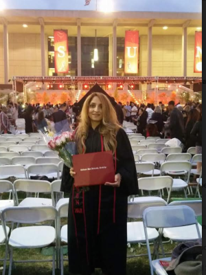 Adineh, who is wearing a graduation cap and gown