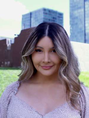 Amarah Martinez with grass and buildings in the background