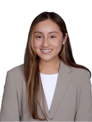 Johanna Bedoy smiling headshot in beige blazer and white top on white background