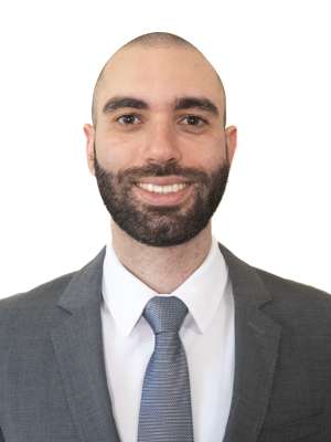 Nicholas Kopoosian in a business suit, smiling at camera