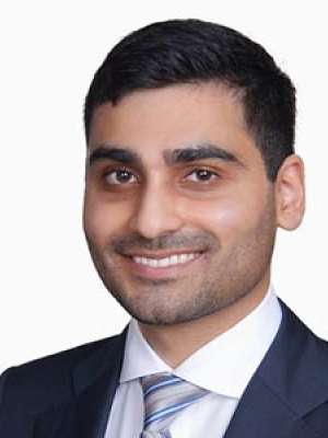 Bhavesh Patel smiling headshot wearing suit and tie