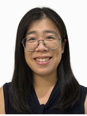 Smiling woman with glasses and dark hair wearing a navy sleeveless top on white background