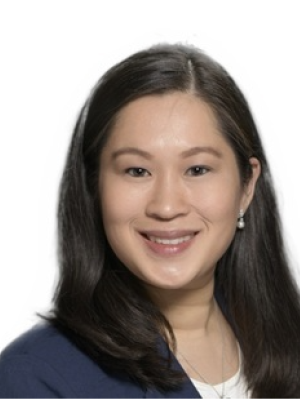 Headshot of person with shoulder-length dark hair wearing a navy blazer