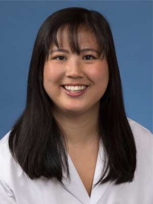 Head shot of Maia Giombetti in white lab coat, smiling at camera