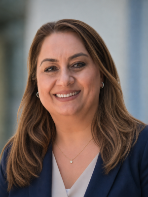 Smiling professional woman headshot wearing a navy blazer and white blouse