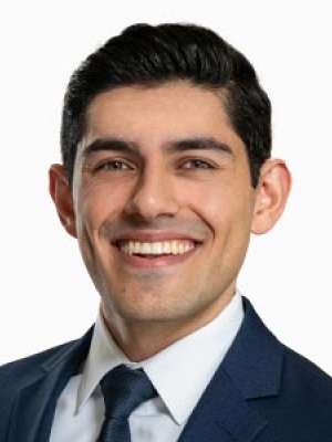 Smiling professional headshot of a person in a suit and tie
