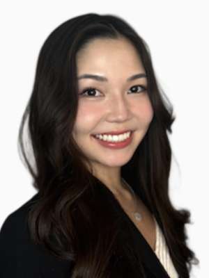 Smiling professional headshot of woman with long dark hair wearing a black blazer