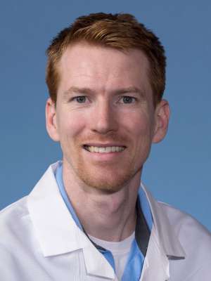 Luke Helmminiak, PhD in a white lab coat