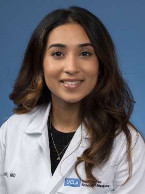 Head shot of Ashni Patel in white lab coat, smiling at camera
