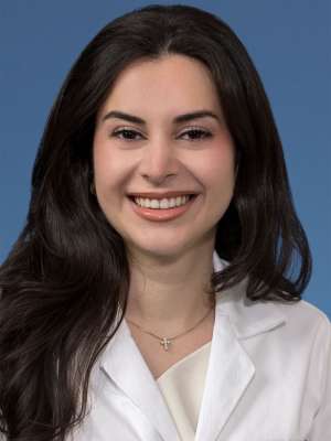 Head shot of Natalie Nabaty, MD in white coat, smiling at the camera