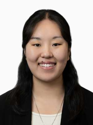 Ji Hae Lee smiling headshot wearing black blazer on white background.