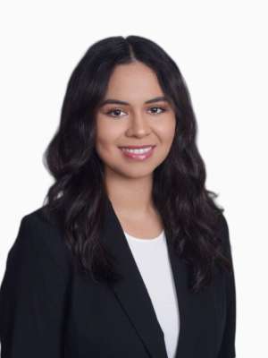 Elizza Villarruel smiling in a black blazer and white top