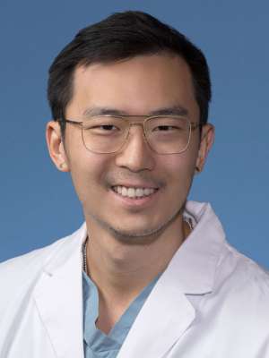 Kenneth Zhu, MD in a white lab coat