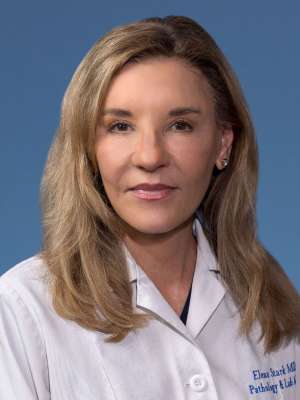Elena Stark, MD, PhD in a white lab coat