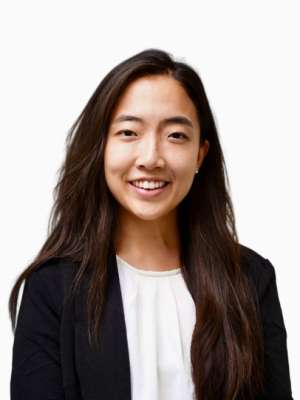 Smiling woman in black blazer and white blouse on white background