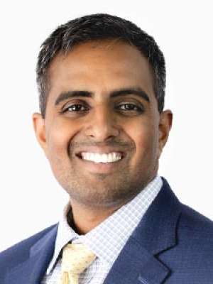 Ramesh Karthik smiling headshot wearing suit and tie