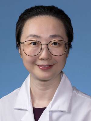 Ruoji Zhou, MD, PhD in a white lab coat