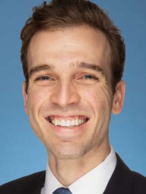 Smiling man in suit and tie against blue background