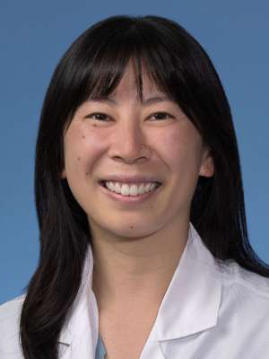 Maggie Tsang, MD in a white lab coat