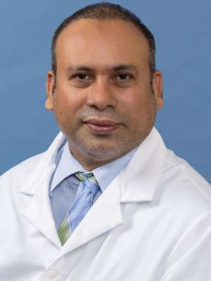 White coat head shot of Sabir Syed, giving a small smile at the camera