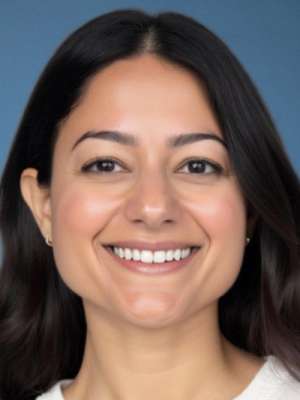 Smiling woman with dark hair and neutral blue-gray background