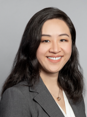 Head shot of Irma Zhang in business attire, smiling at camera.