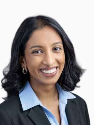 Headshot of an unidentified woman smiling in a blazer and collared shirt.