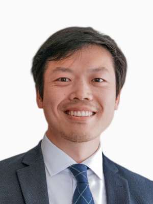 Professional headshot of a smiling person in a suit and tie