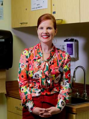 Kaiyti Duffy standing in a clinic exam room wearing a floral blouse