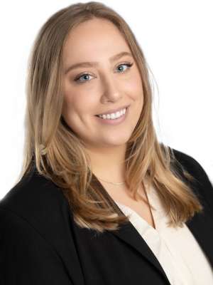 Smiling woman in black blazer and white blouse on white background