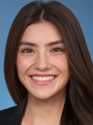 Smiling woman headshot with long dark hair and blue background