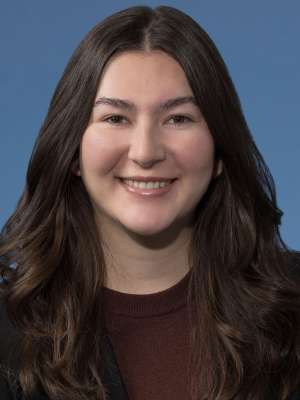 Woman smiling headshot with blue background