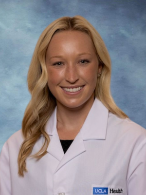 headshot of Dr. Andrea Antenucci wearing a white lab coat in an indoor setting with a blue background