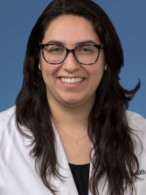 Head shot of Brenda Gutierrez, MD, PhD in a white coat, smiling at the camera