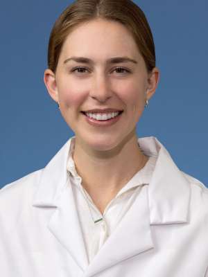 Head shot of Clare Schrodt, MD in white lab coat, smiling at camera